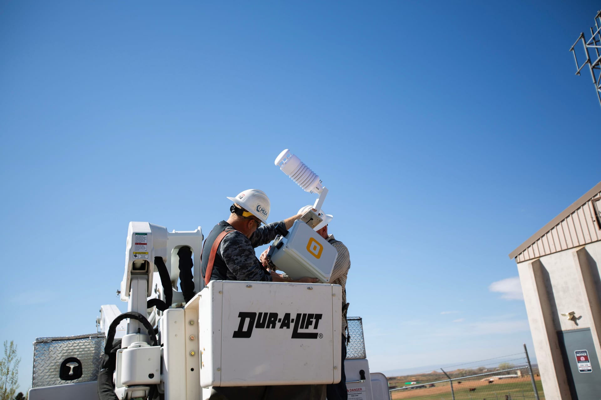 Field technician installing a WatchPost sensor enclosure on infrastructure